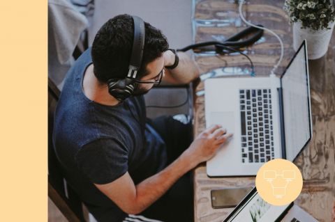Joven con audifonos en su macbook pro