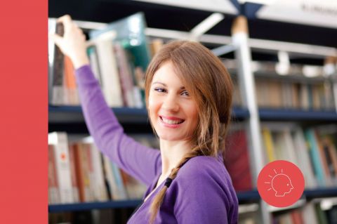 Joven eligiendo un libro de un estante